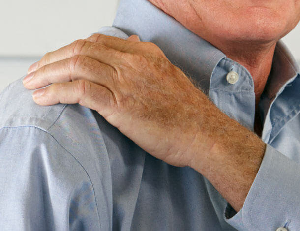 Man gripping arm in pain from shoulder labrum tear
