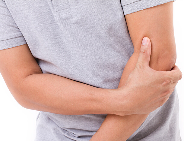 Man with radial tunnel syndrome holding elbow in pain